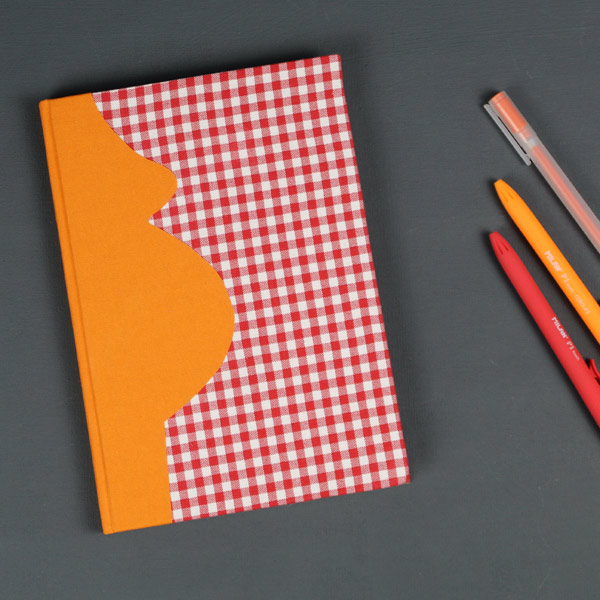 Orange Schwangerschaftstagebuch mit rotem Vichykarostoff