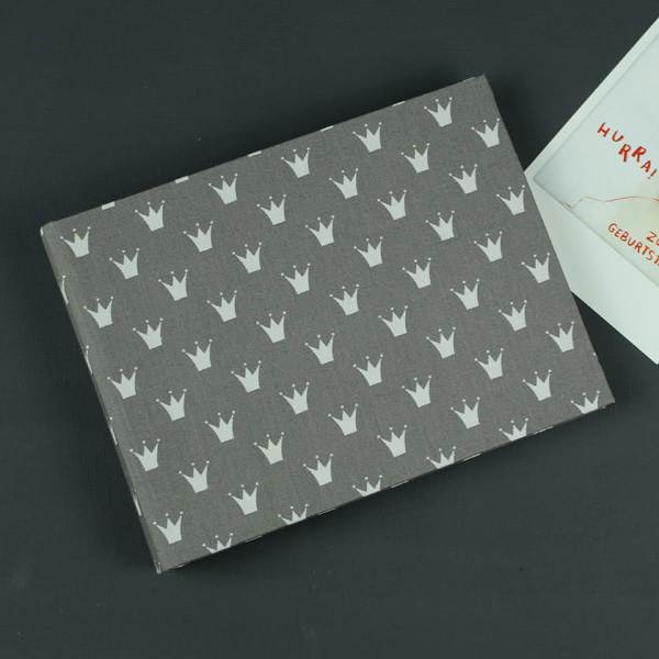 Kleines taupe farbenes Babyfotoalbum mit weißen Krönchen