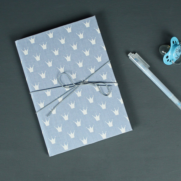 Blau weiß gemustertes Babytagebuch mit weißen Krönchen
