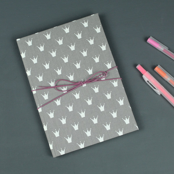 Taupe farbenes Babytagebuch mit kleinen weißen Krönchen