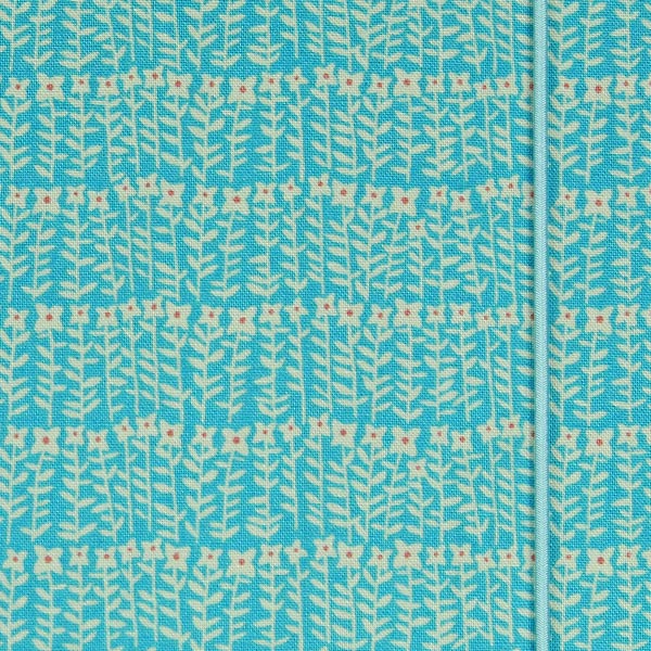 Mit hellblau weiß gemustertem Stoff bezogenes Notizbuch