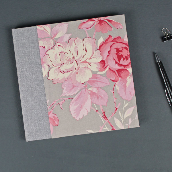 Hellgraues Gästebuch mit großen rosa Rosenblüten