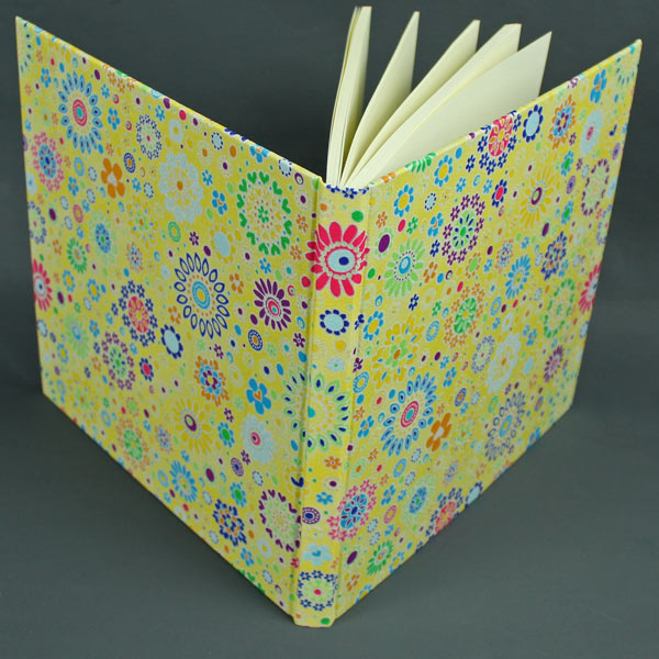 Stoff bezogenes gelb bunt gemustertes quadratisches Gästebuch