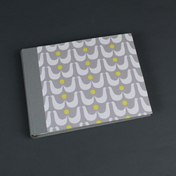 Kleines grau weiß gemustertes Babyfotoalbum mit weißen Vögeln