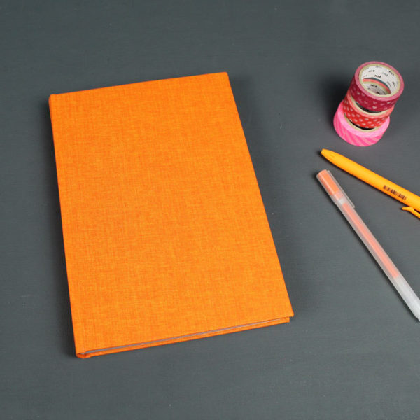 Leuchtend orange farbenes Notizbuch