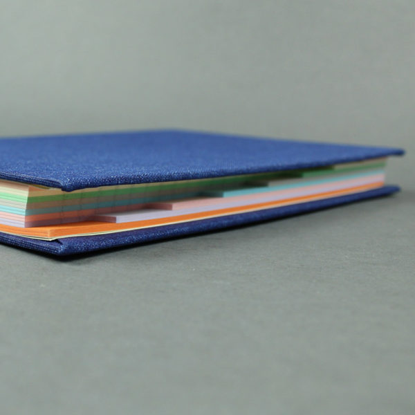 Liniertes blaues Notizbuch mit bunten Registerseiten