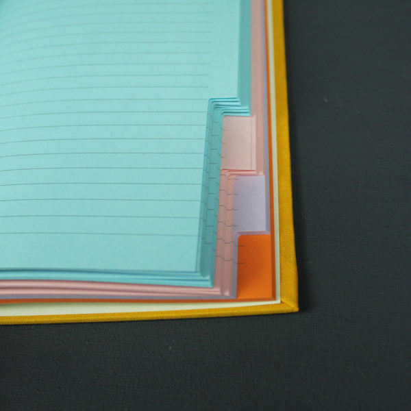Gelbes DIN A5 Notizbuch mit bunten Registerseiten