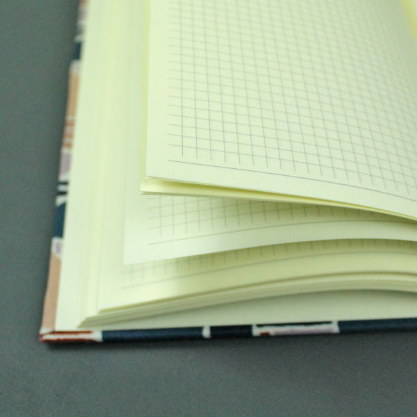 Kariertes Notizbuch mit einem blau gemusterten Stoff bezogen