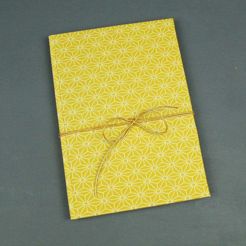 Notizbuch gelbes Sternchenmuster mit goldenem Lederband